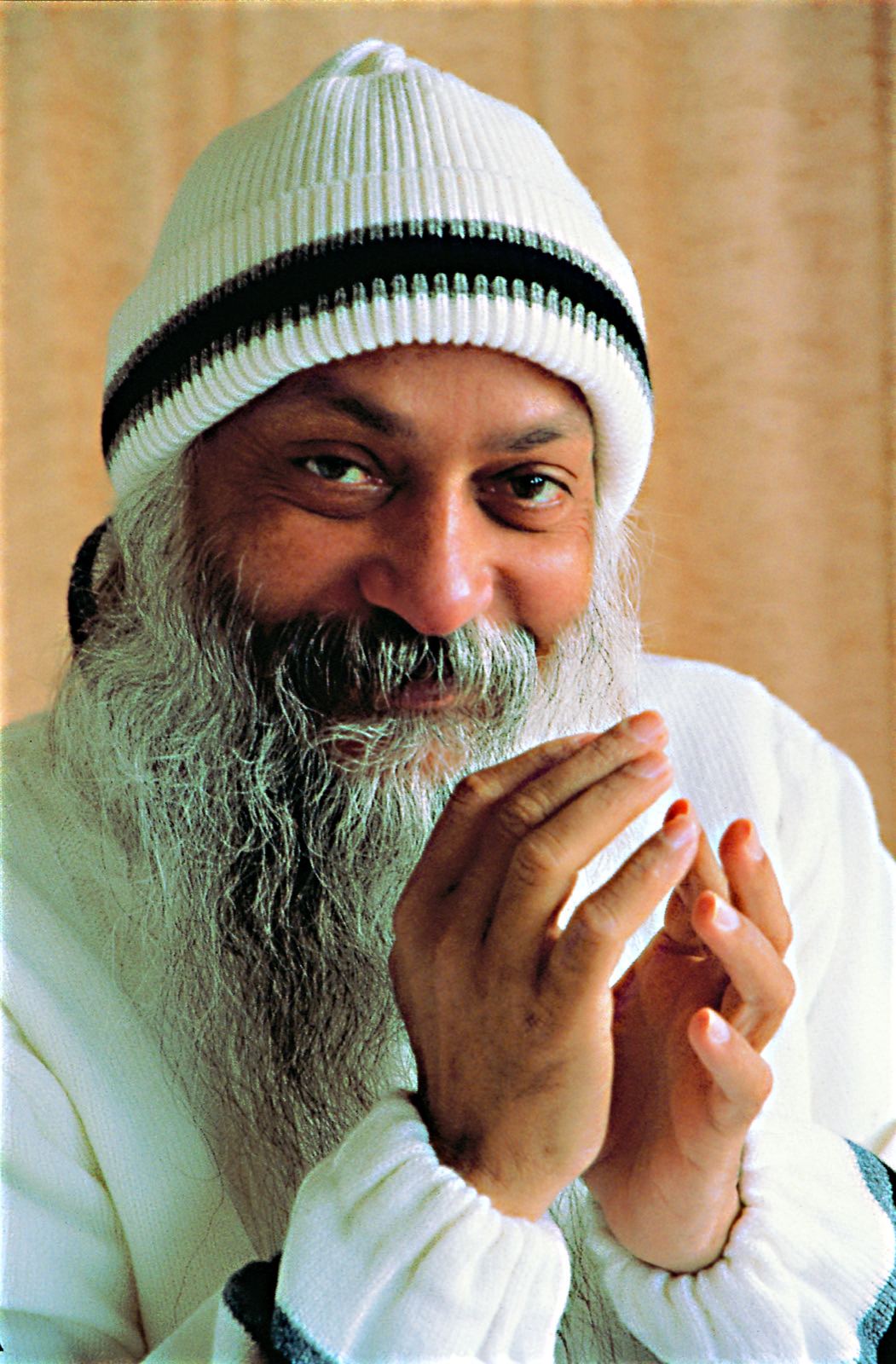 Osho smiling with hands folded